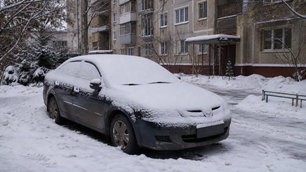 Автомобиль во дворе жилого дома зимой